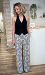 Femme portant un pantalon fluide noir et blanc imprimé graphique 