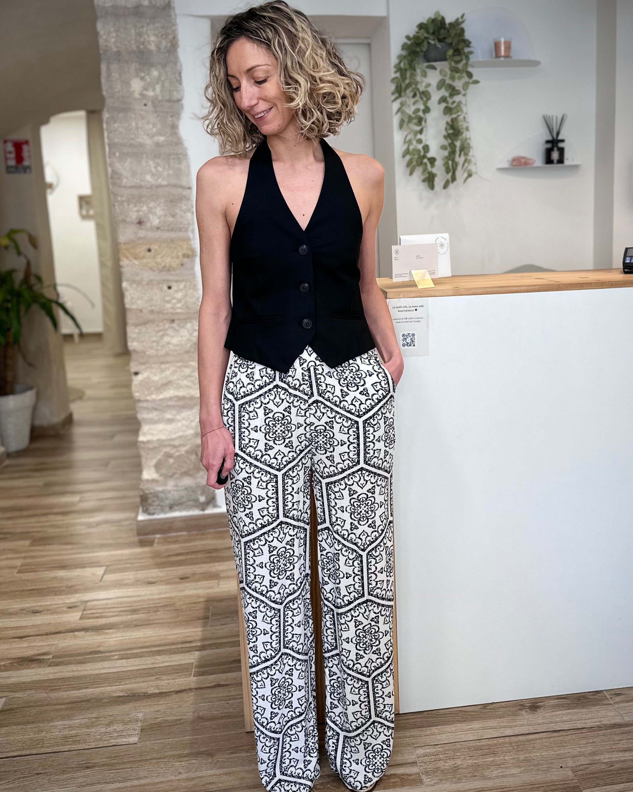 Femme portant un pantalon fluide noir et blanc imprimé graphique 