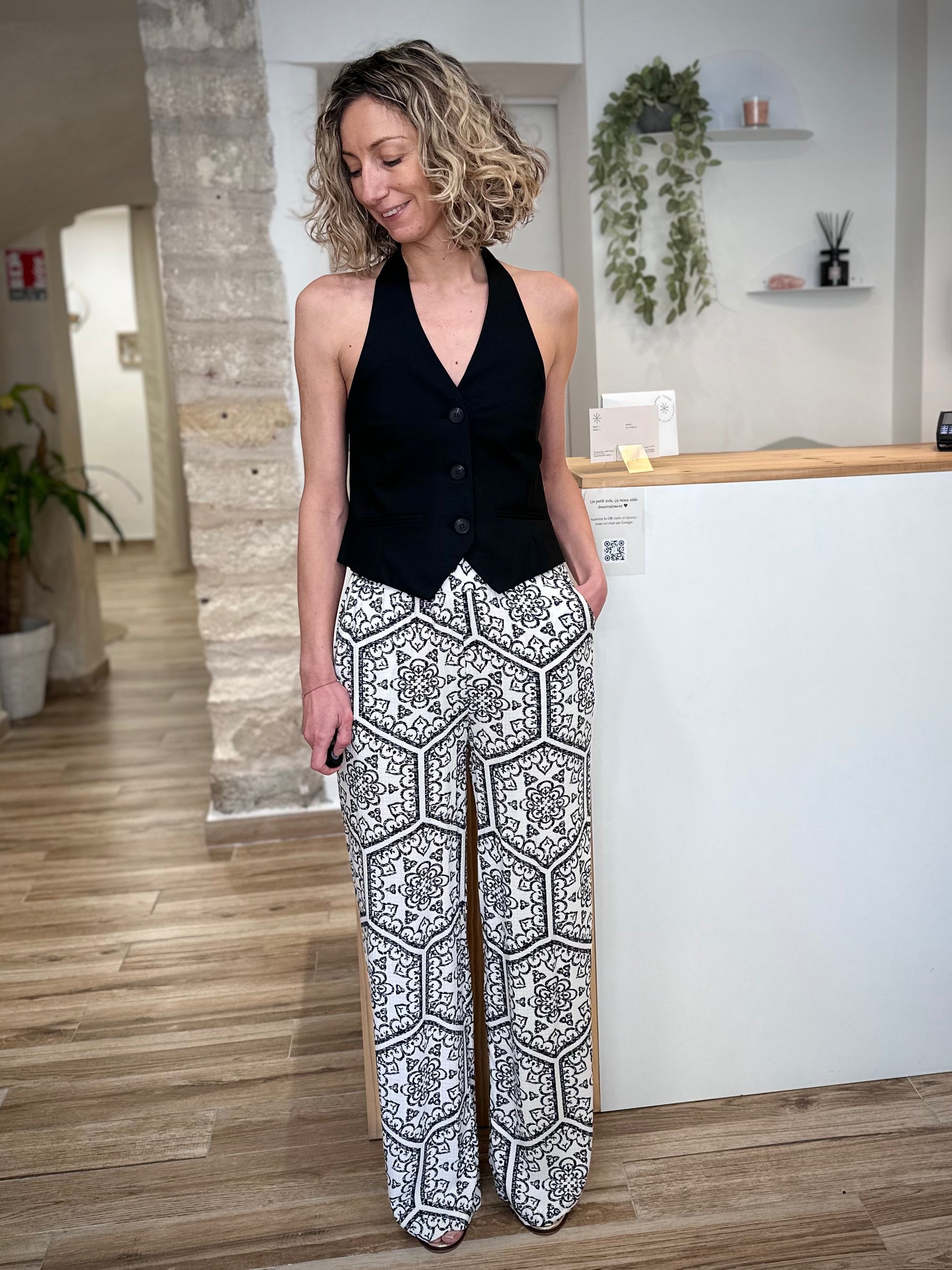 Femme portant un pantalon fluide noir et blanc imprimé graphique 