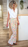 Silhouette féminine portant un pantalon coloré brodé