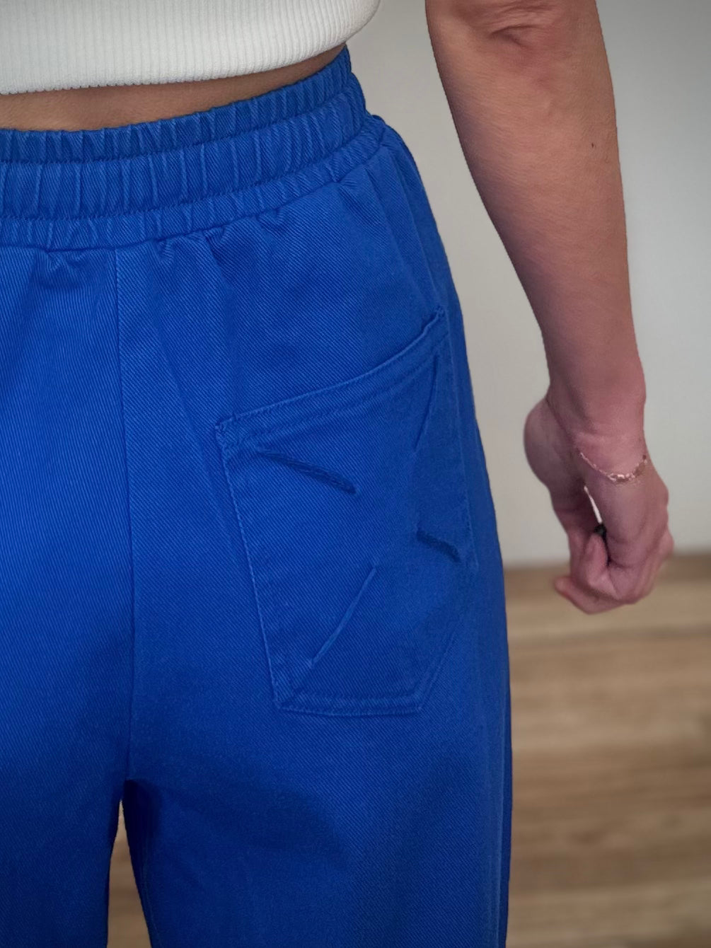 Détail broderie croix poche arrière pantalon 