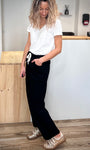 Femme en mouvement portant un pantalon noir ample tendance