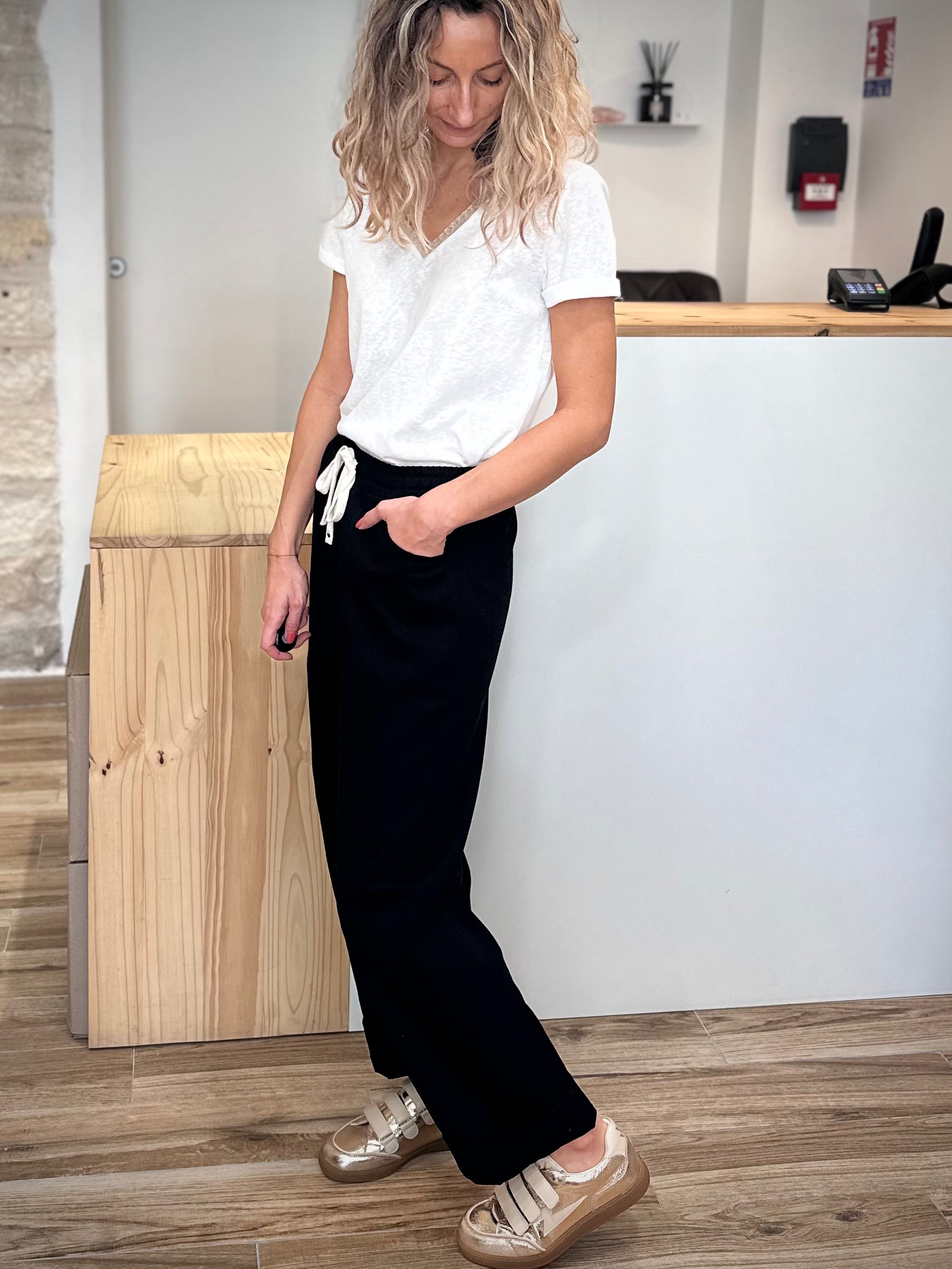 Femme en mouvement portant un pantalon noir ample tendance