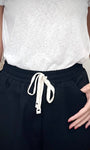 Détail de la taille élastiquée avec cordon d’un pantalon noir