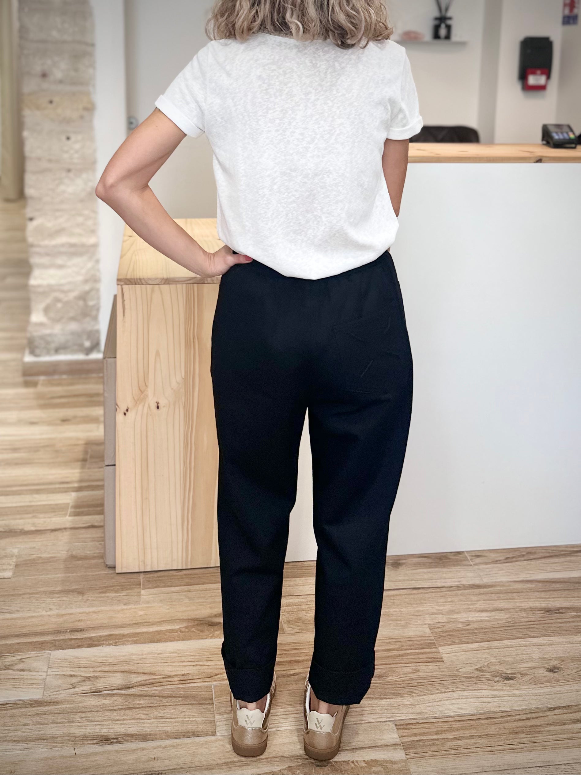 Dos d’un pantalon ample noir avec broderie ton sur ton
