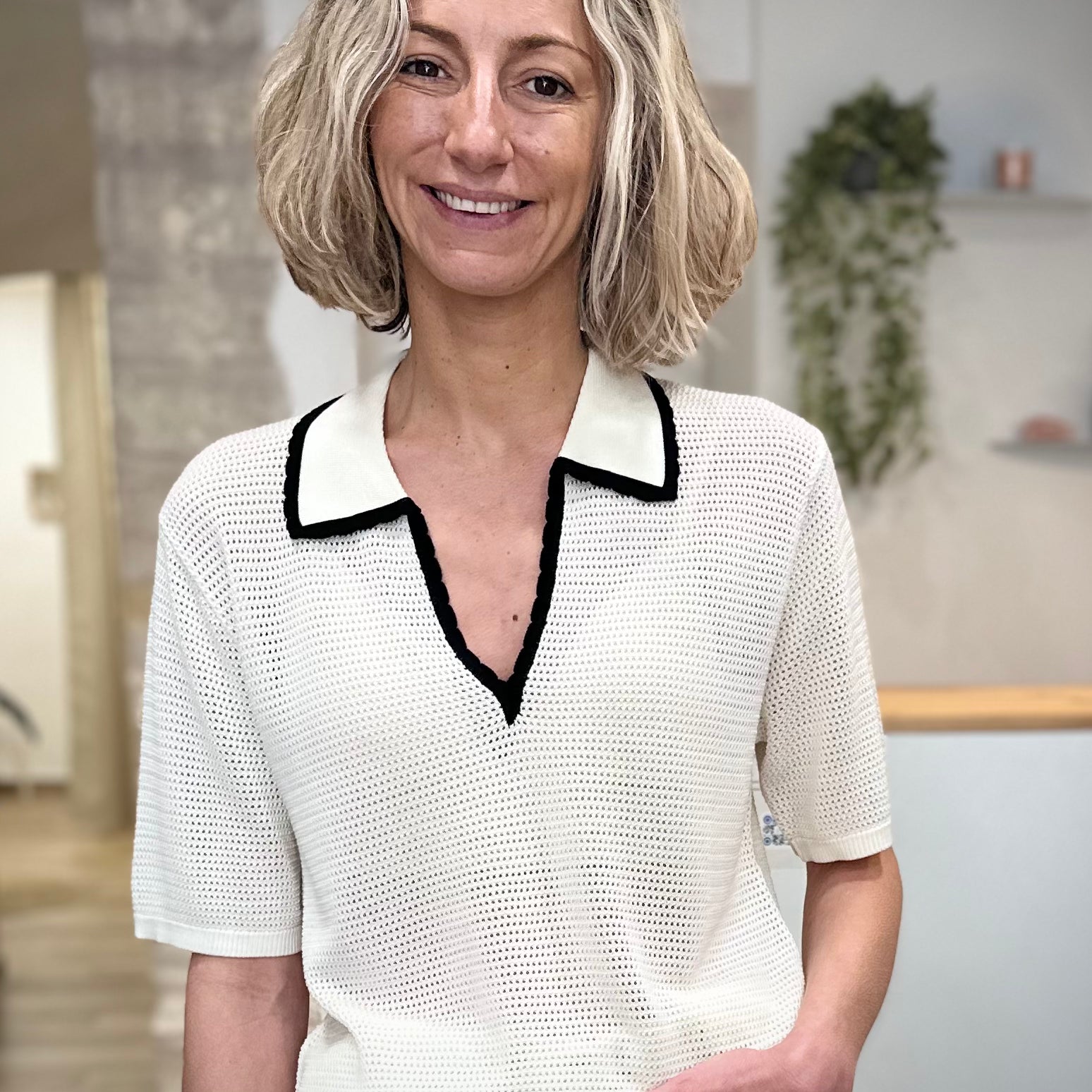 Femme portant un polo ivoire en maille ajourée 