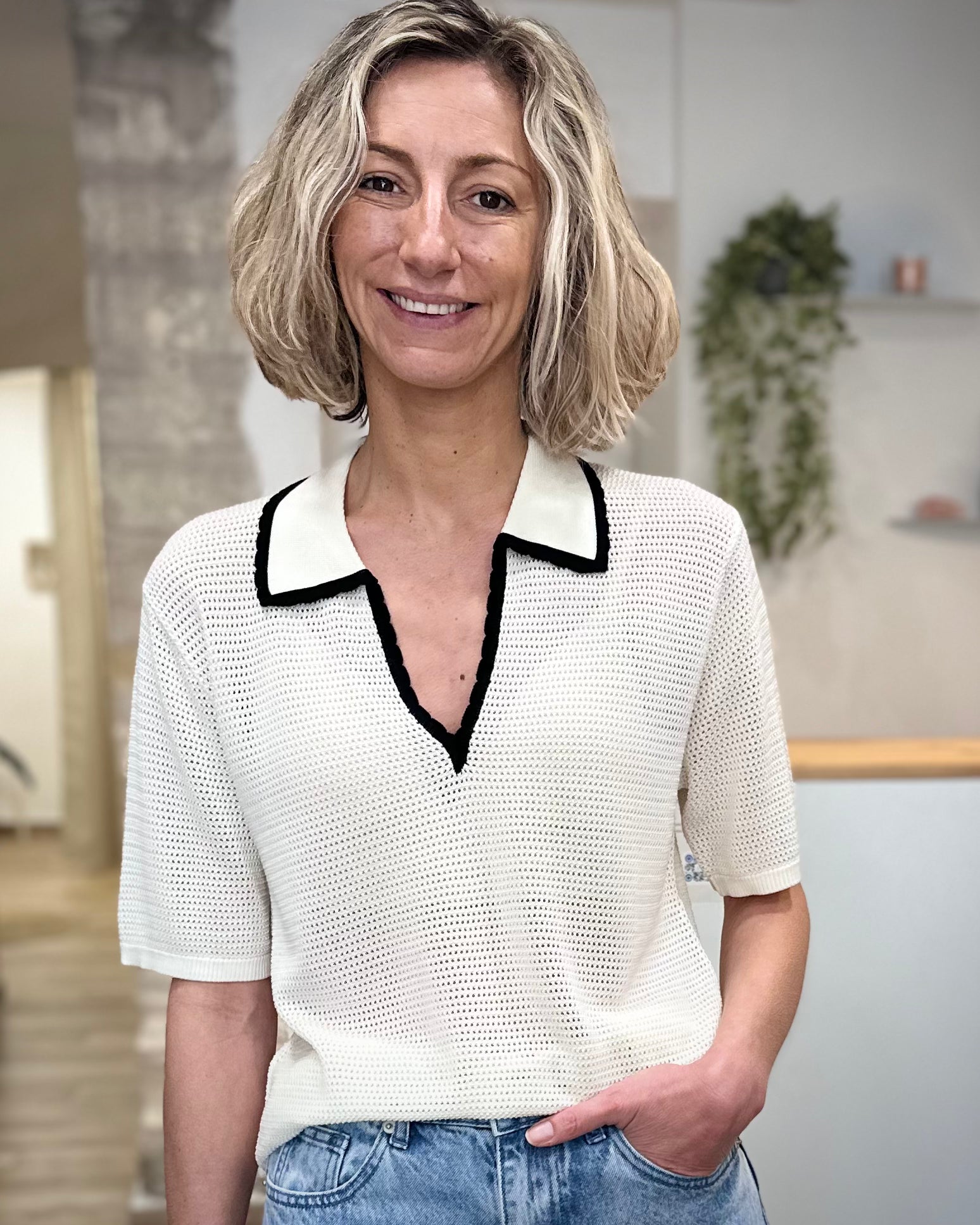 Femme portant un polo ivoire en maille ajourée 