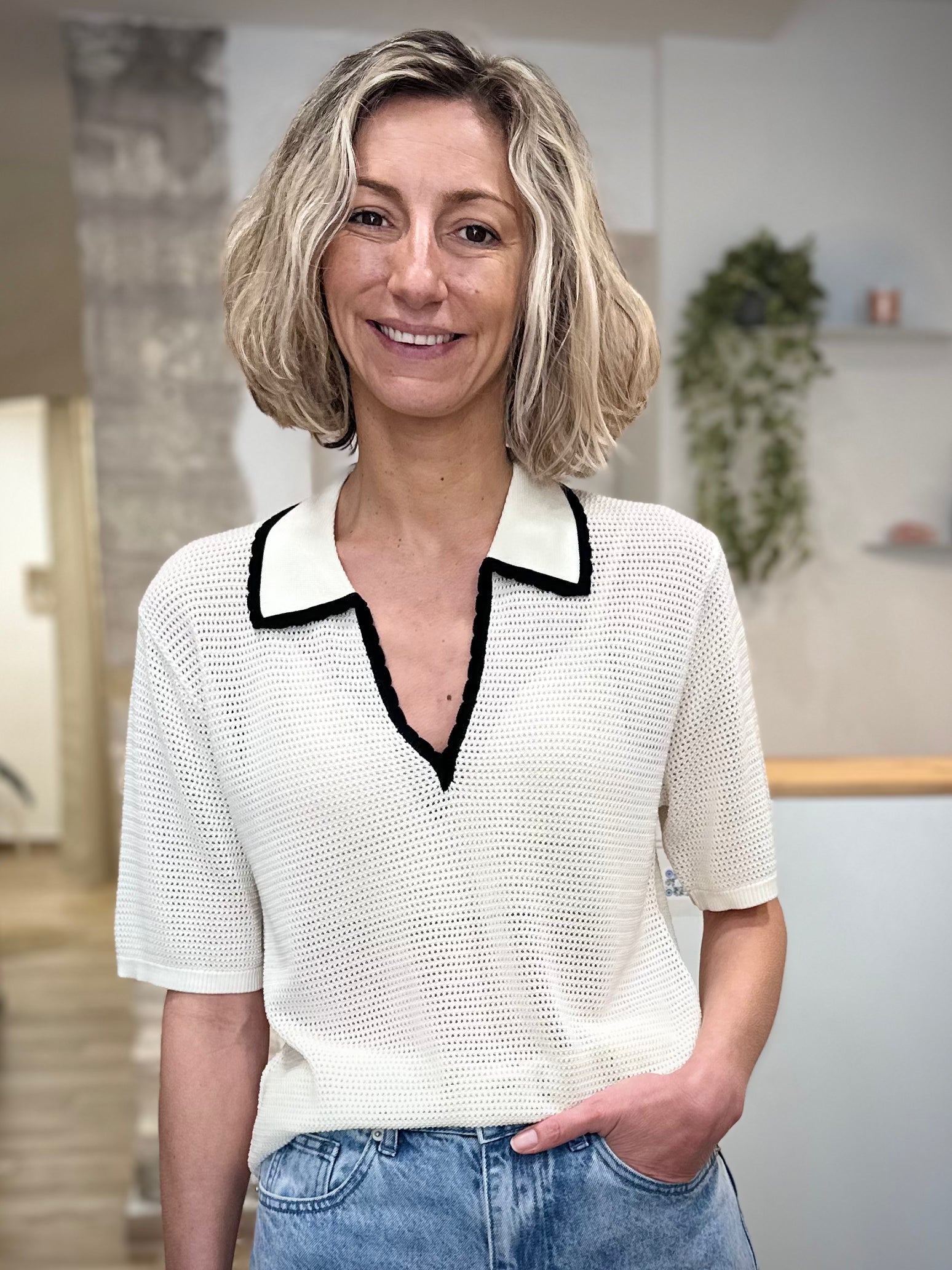 Femme portant un polo ivoire en maille ajourée 