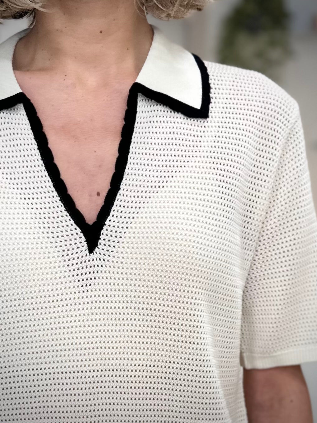 Détail col contrasté noir polo femme élégant 