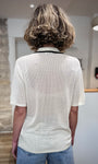 Femme de dos portant un polo maille légère ajourée 
