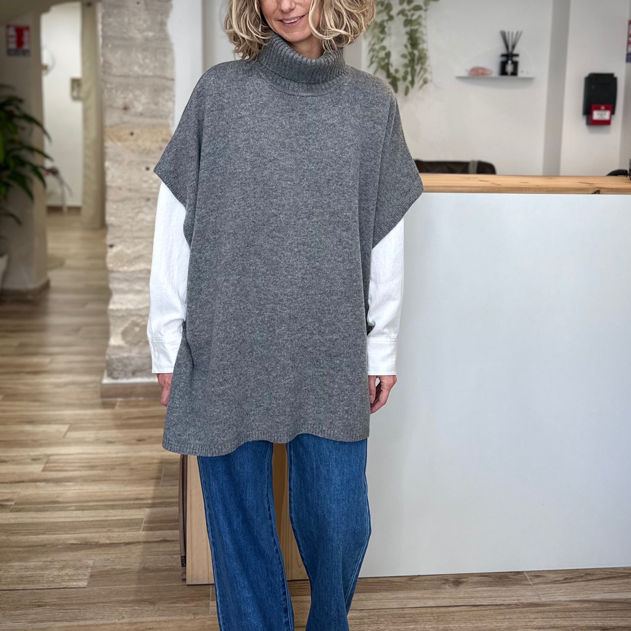 Femme portant un poncho en maille anthracite col roulé