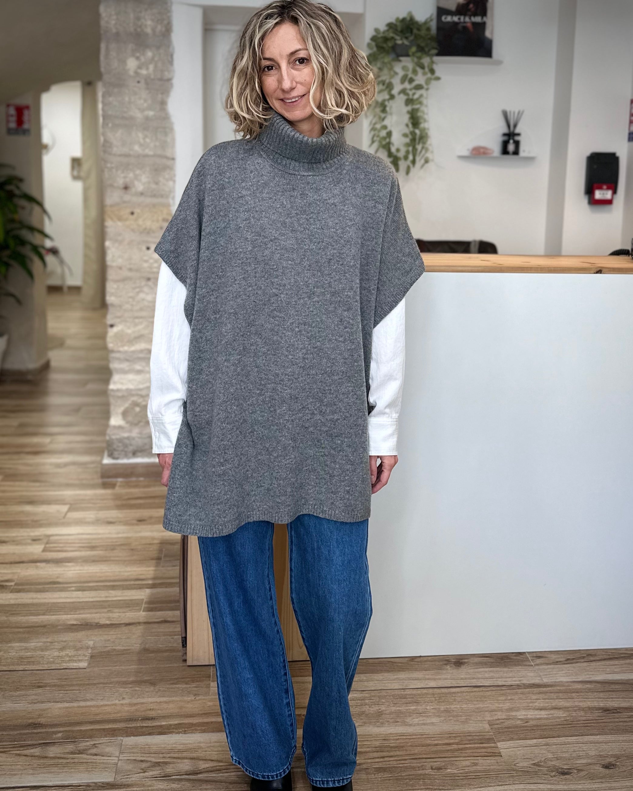 Femme portant un poncho en maille anthracite col roulé