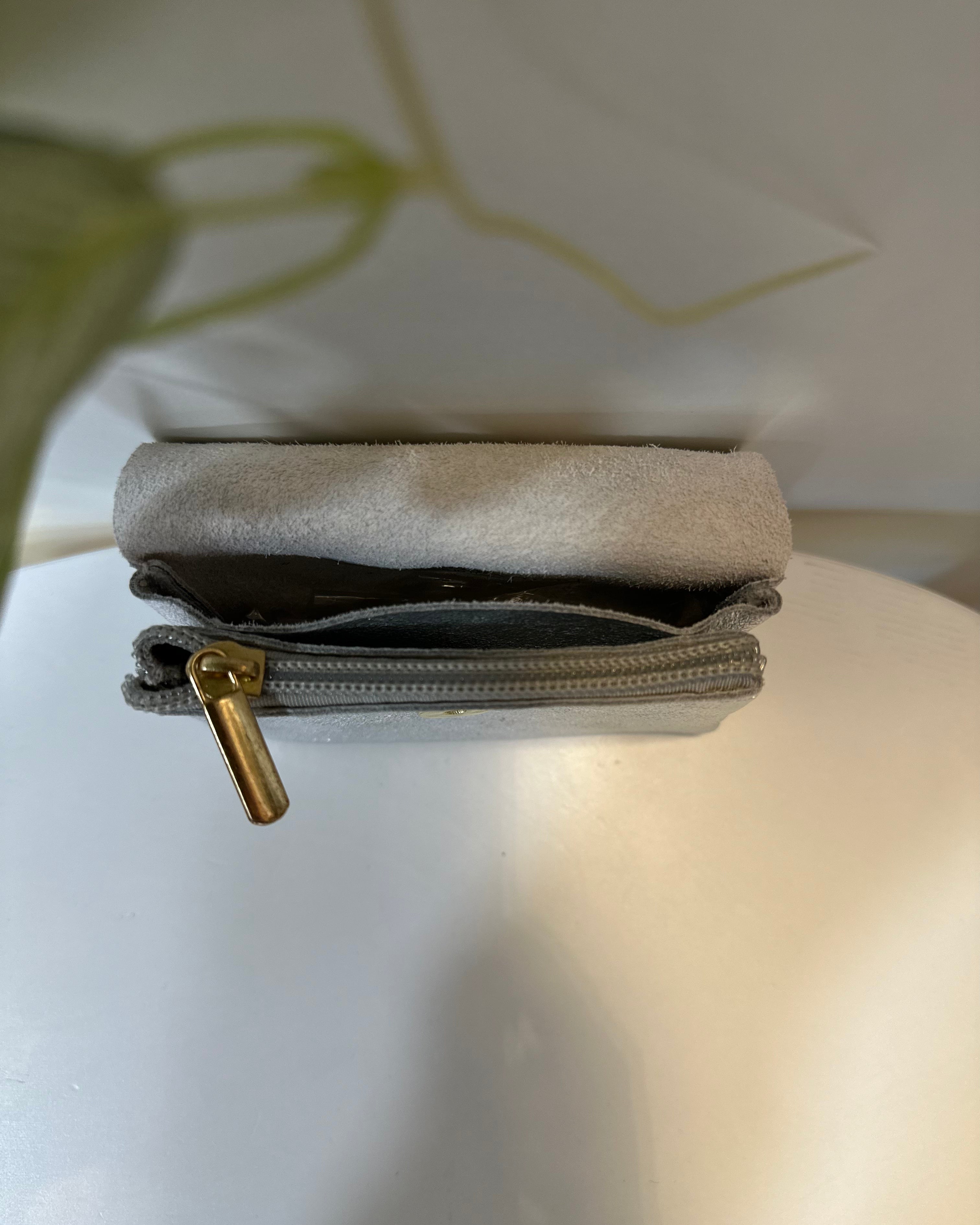 Porte-monnaie argenté ouvert montrant les compartiments