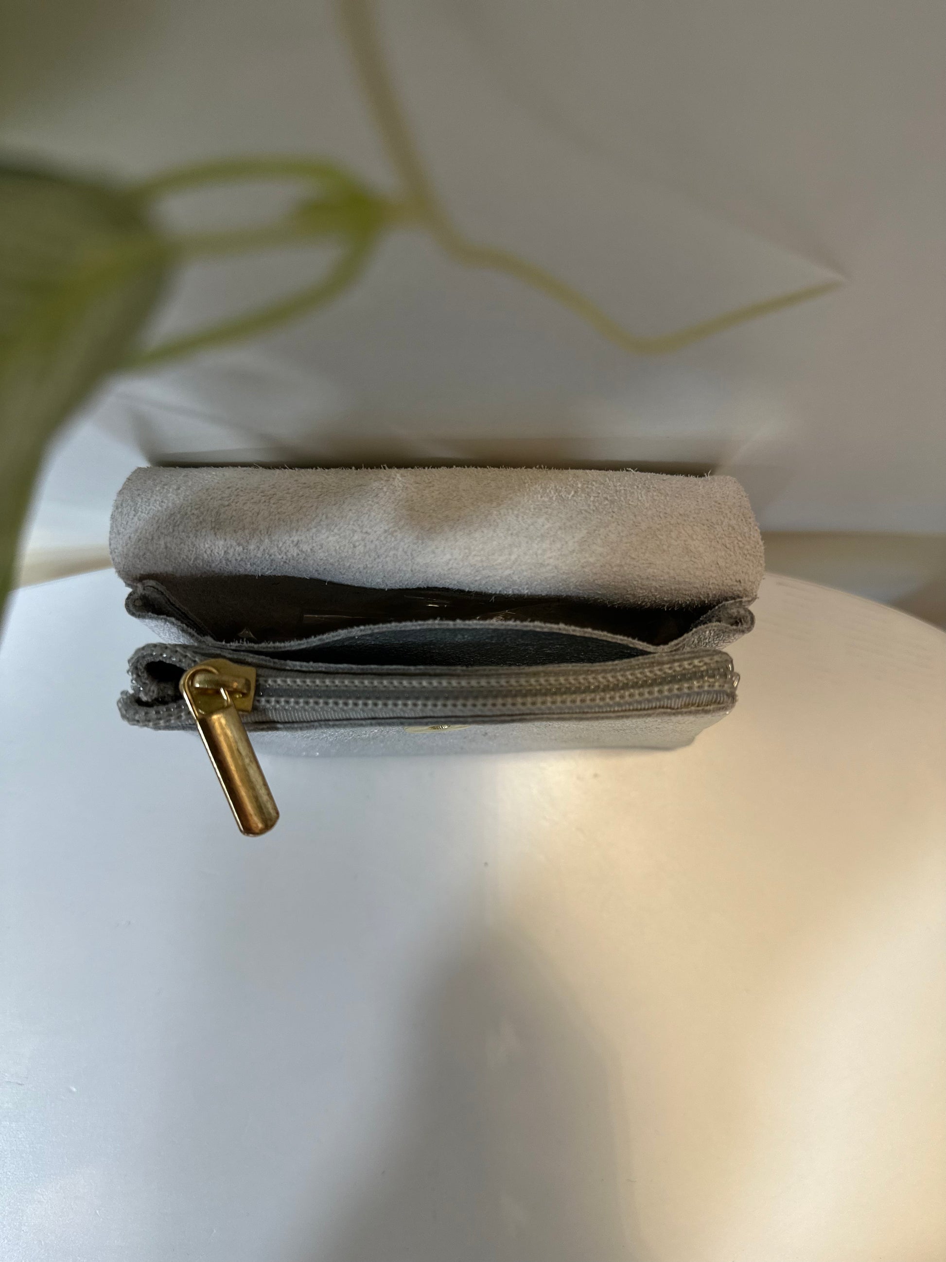 Porte-monnaie argenté ouvert montrant les compartiments