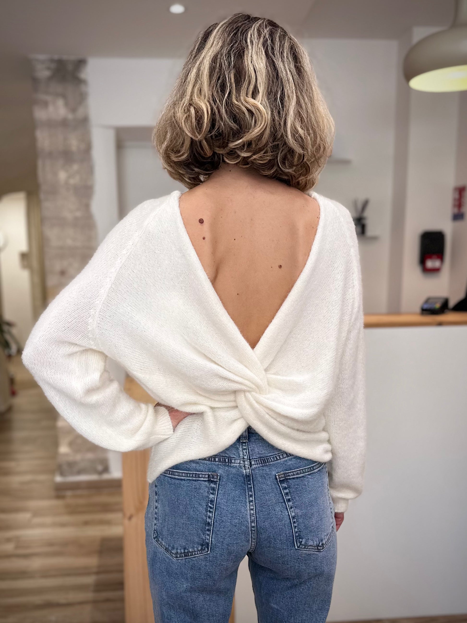 Détail du twist drapé au dos du pull