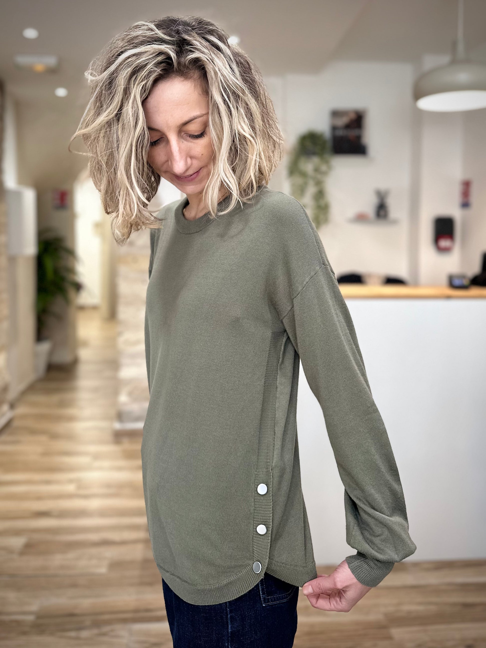Détail boutons argentés sur pull kaki