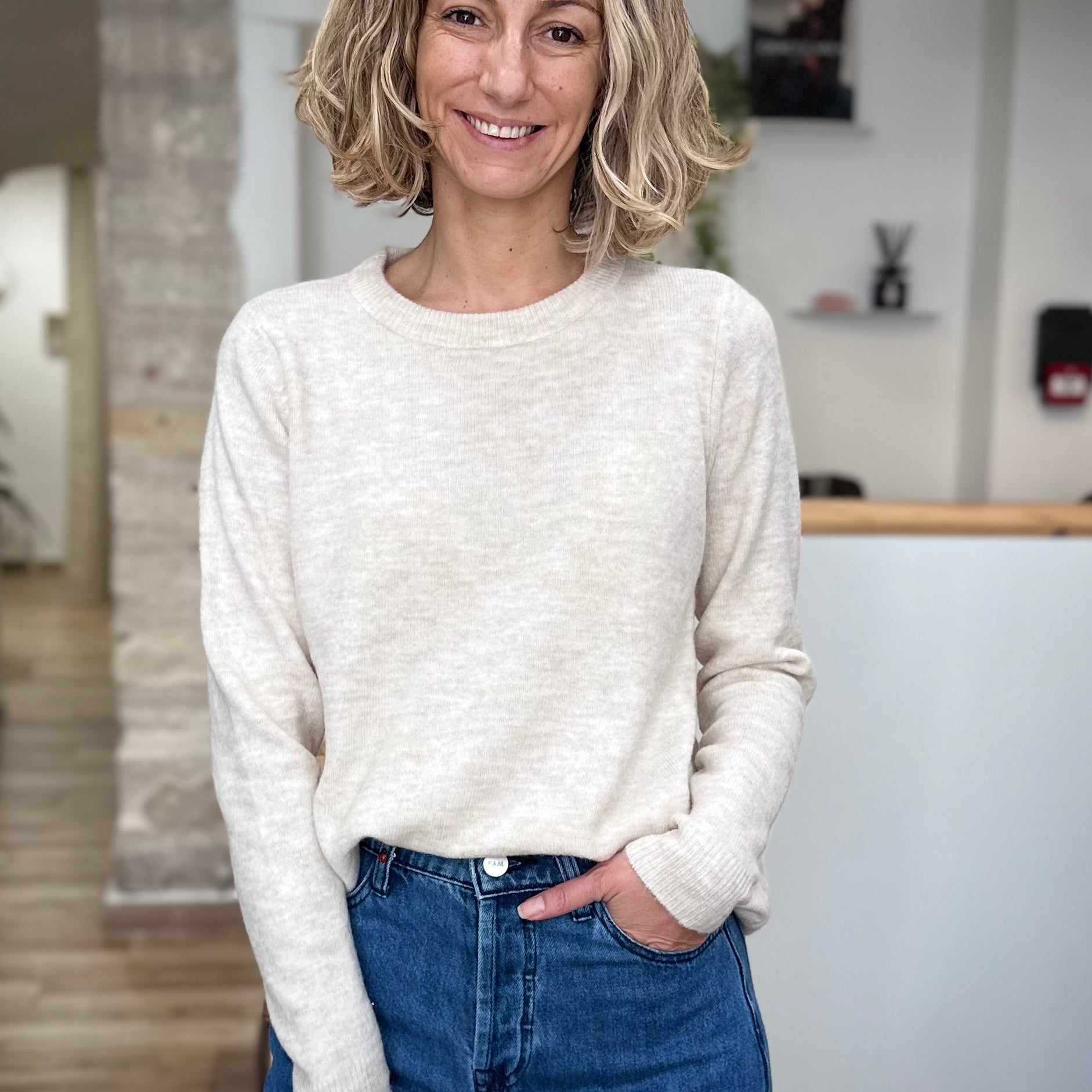 Femme portant un pull beige chiné à manches ajustées