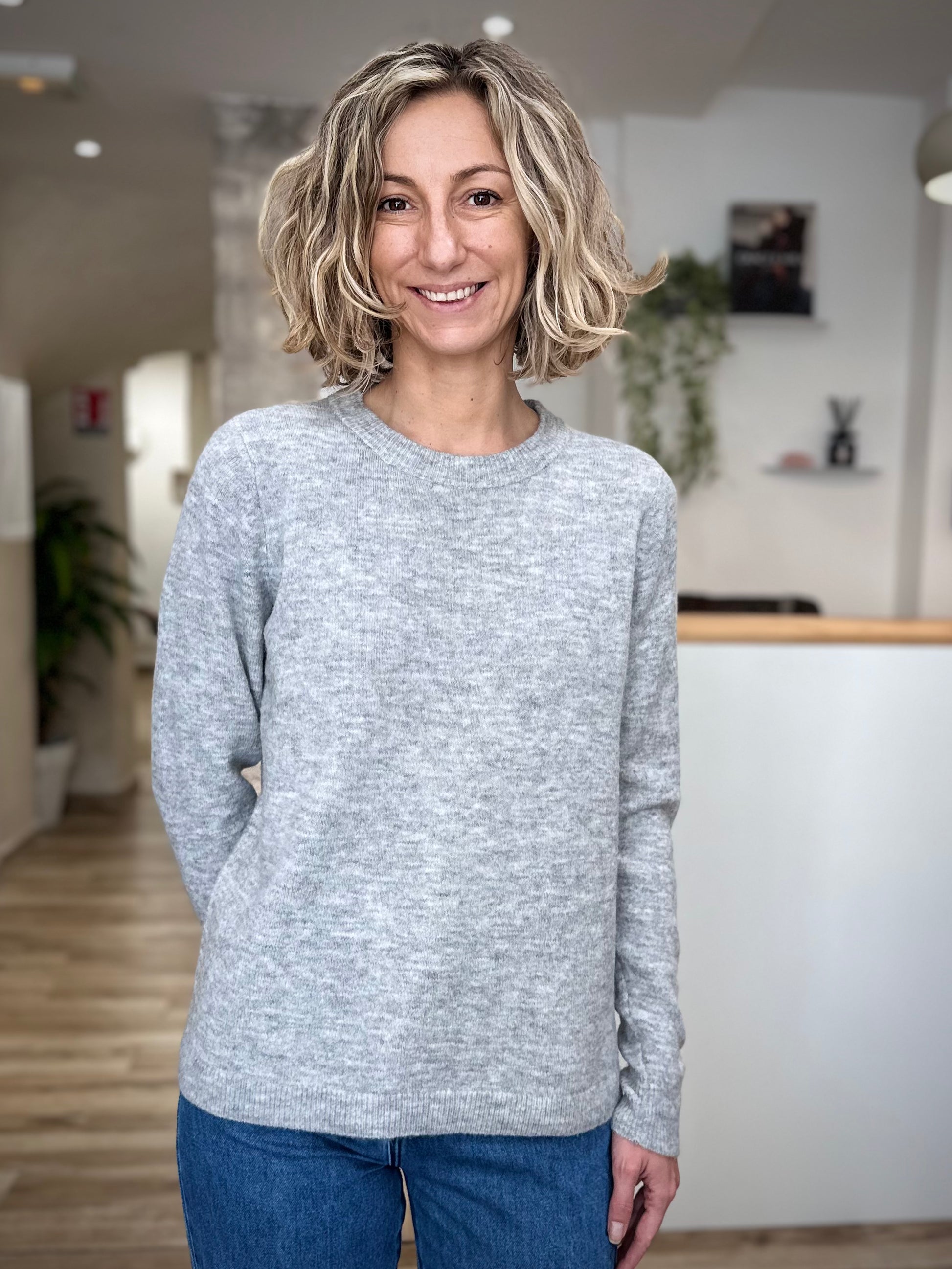 Tombé naturel du pull gris sur les hanches