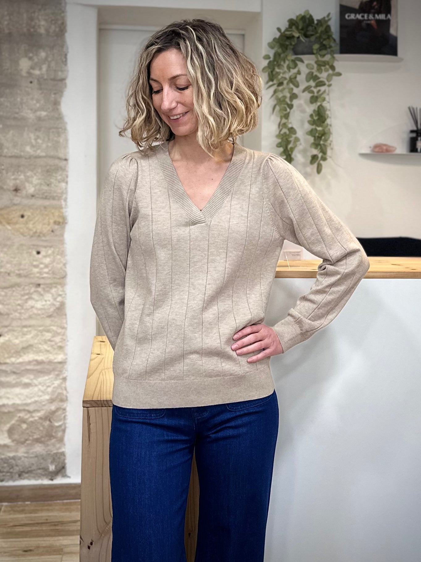 Pull beige manches longues porté par une femme