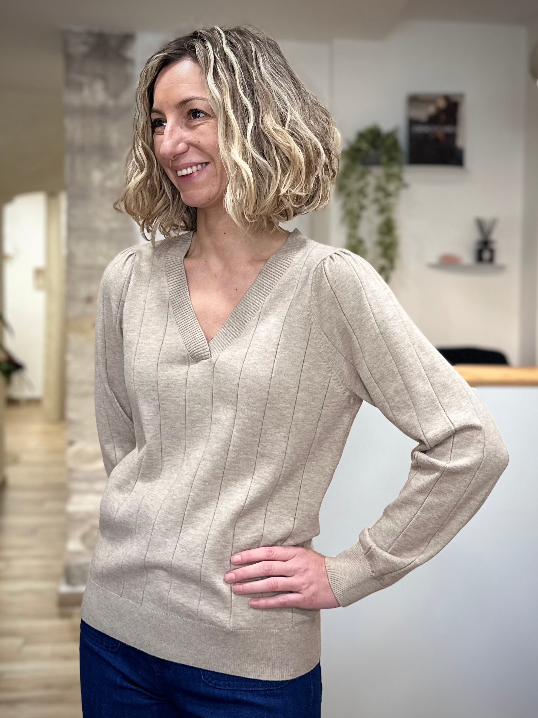 Femme souriante portant un pull beige