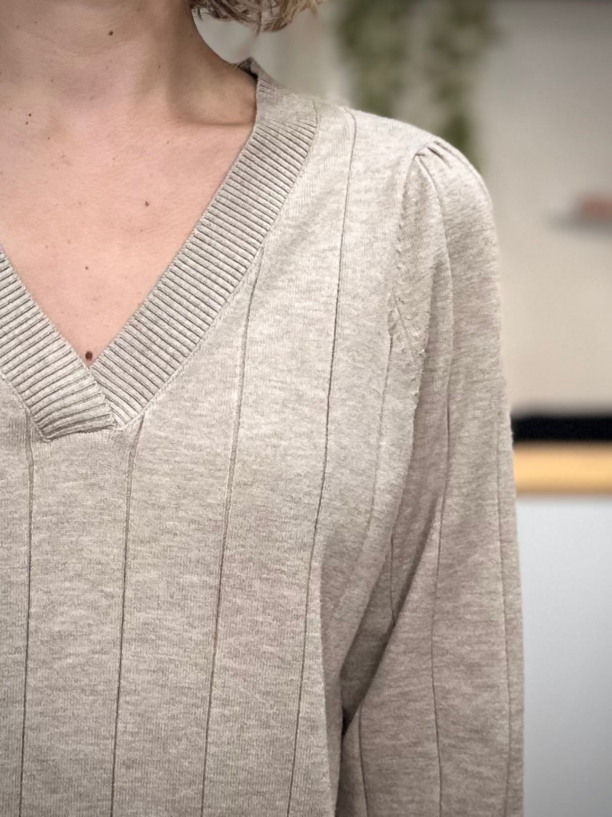 Détail du col V du pull beige