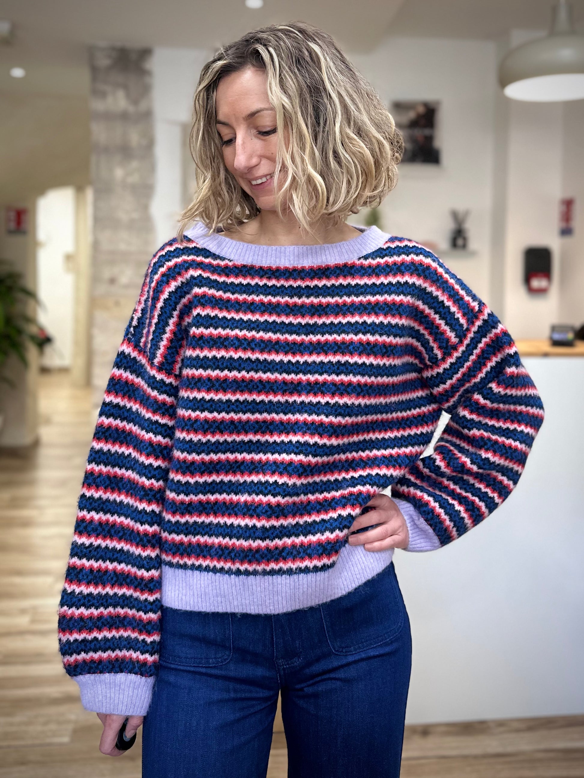 Femme portant un pull oversize à rayures multicolores