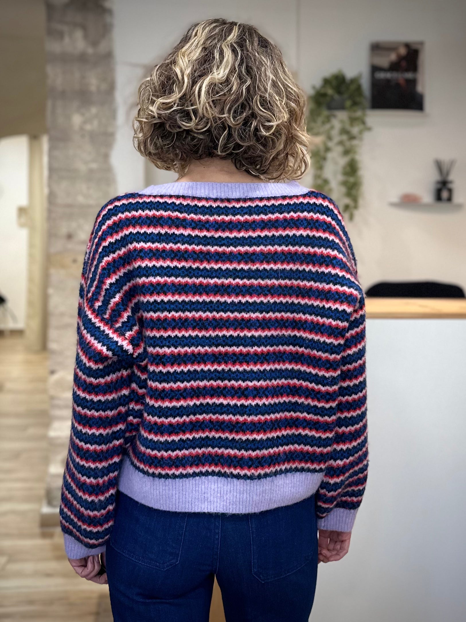 Look d’hiver avec pull multicolore et jean de dos