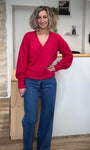 Femme portant un pull rose à col V en maille souple