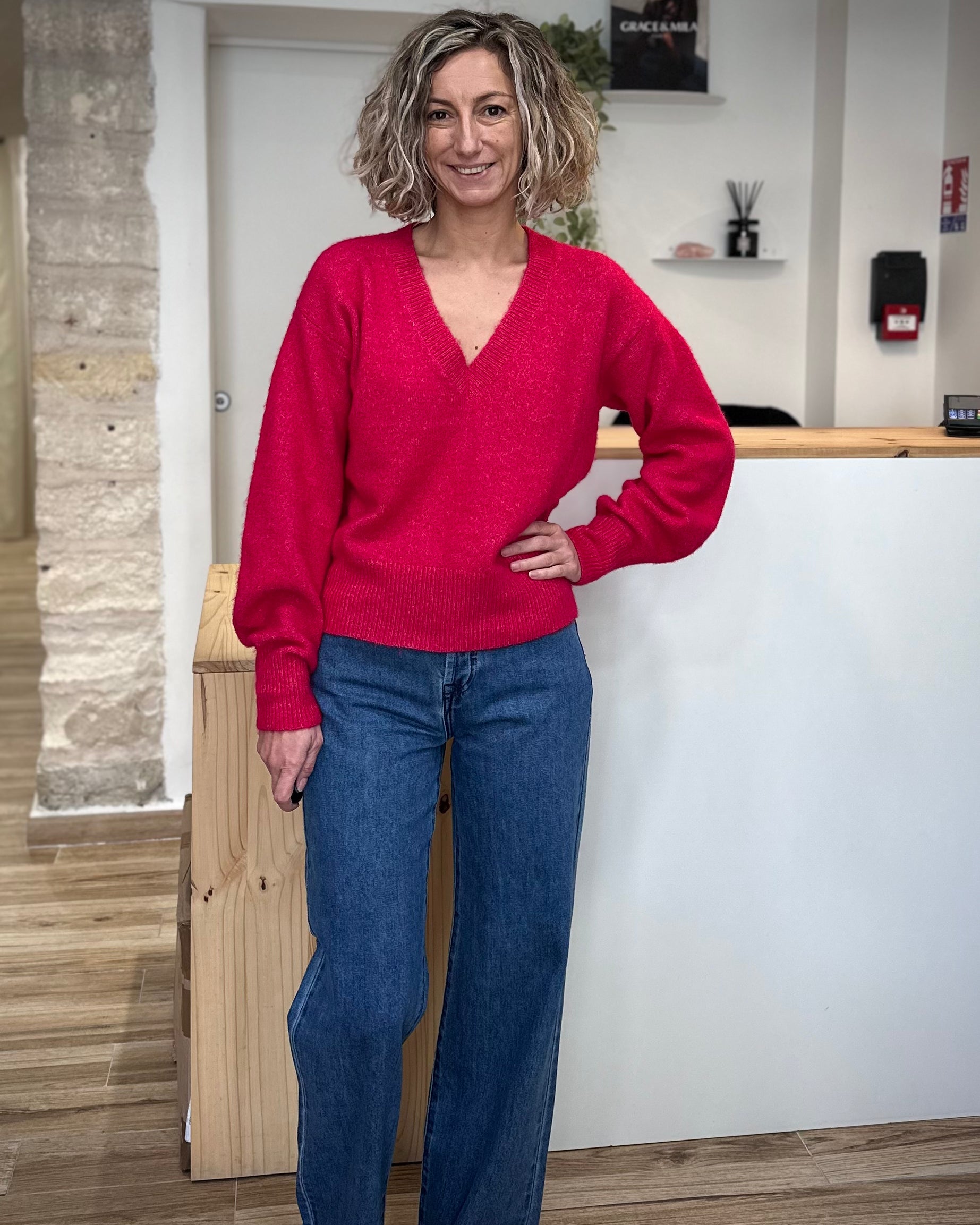 Femme portant un pull rose à col V en maille souple