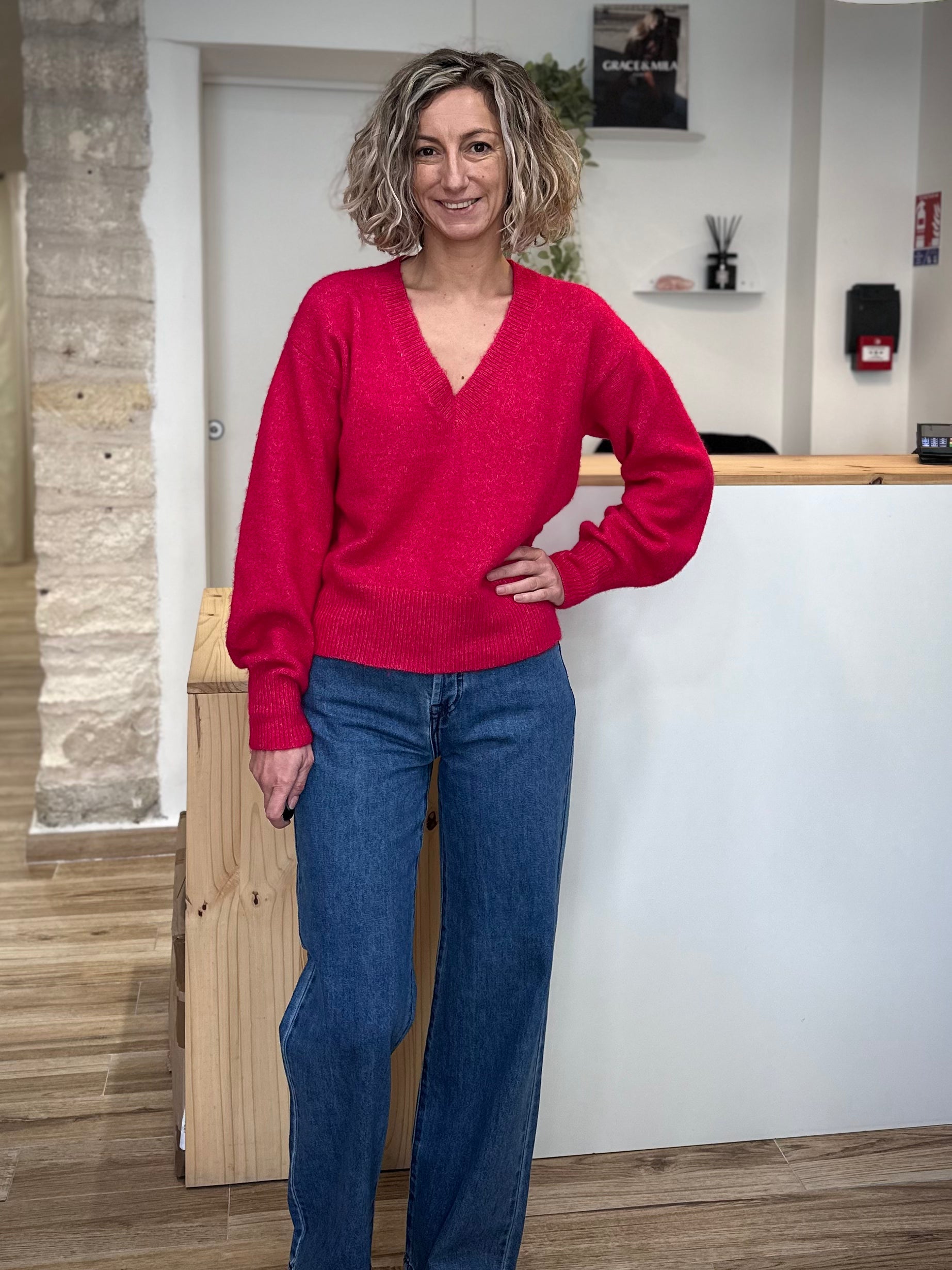 Femme portant un pull rose à col V en maille souple