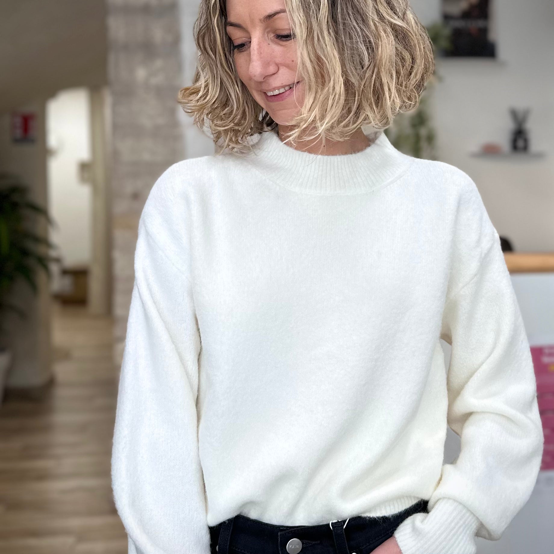 Femme portant un pull blanc à col rond élégant
