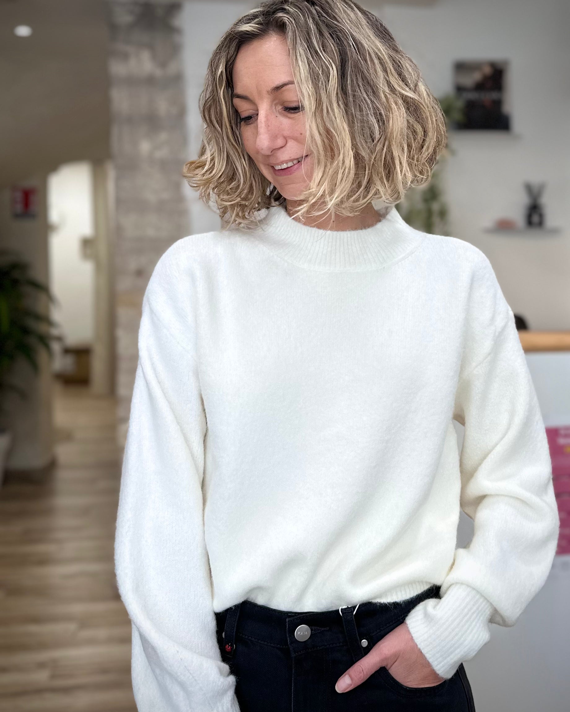 Femme portant un pull blanc à col rond élégant