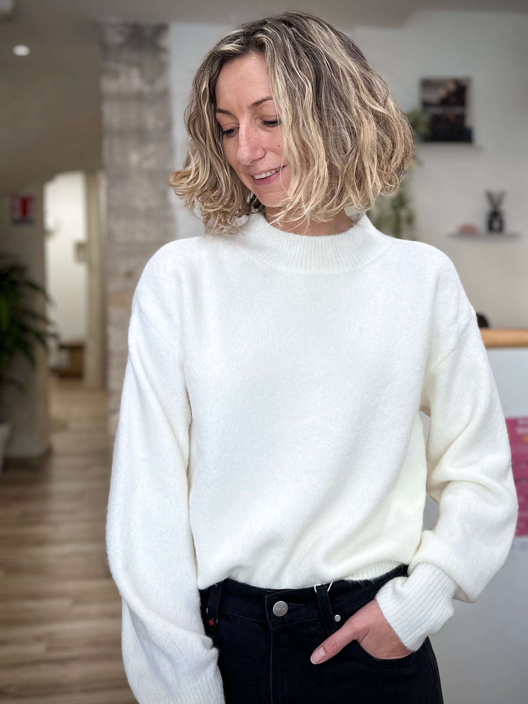 Femme portant un pull blanc à col rond élégant