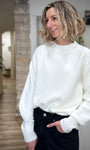 Femme souriante portant un pull blanc cocooning