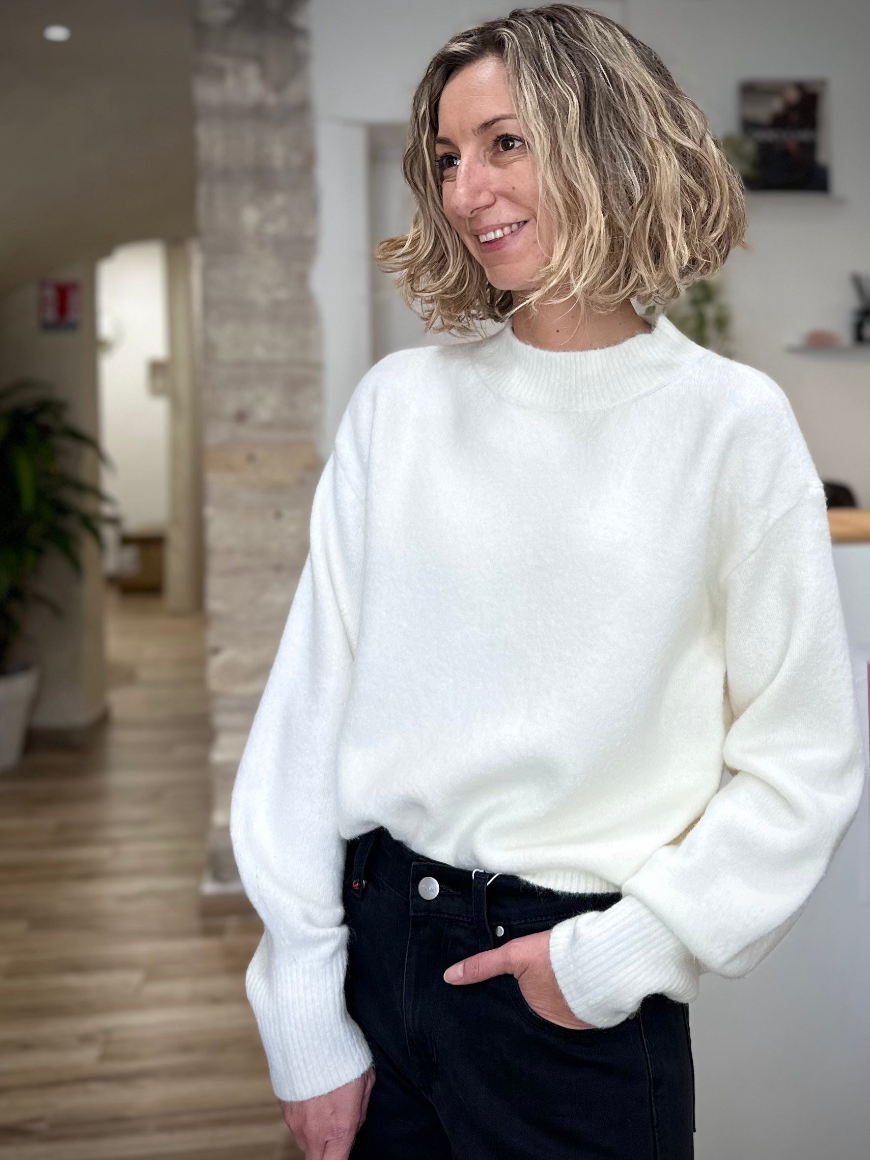 Femme souriante portant un pull blanc cocooning