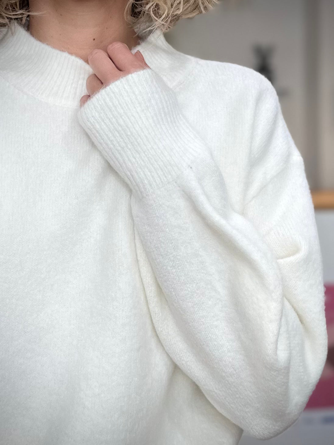 Détail du col rond montant du pull blanc femme