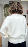 Femme debout de dos portant un pull blanc lumineux casual chic