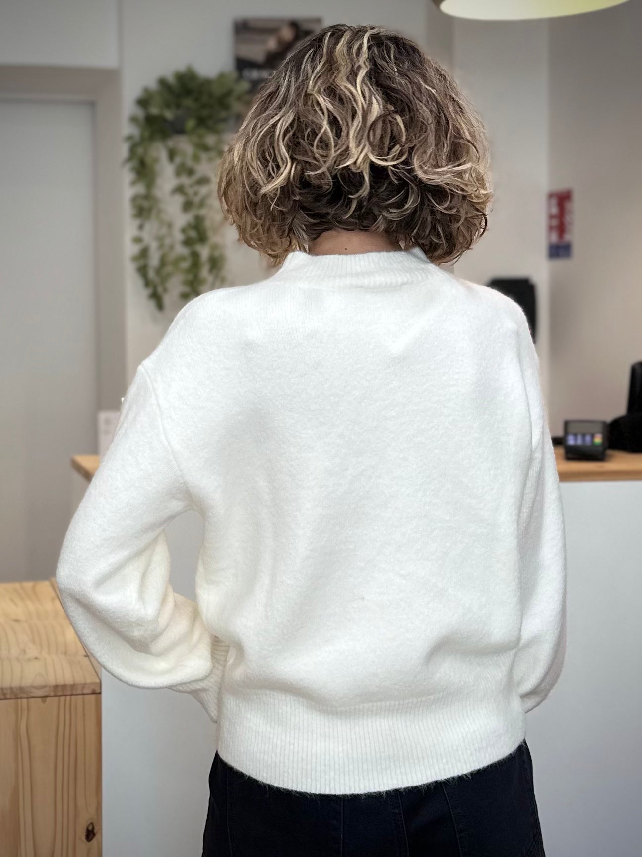 Femme debout de dos portant un pull blanc lumineux casual chic