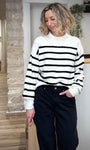 Femme portant un pull blanc rayé noir à col rond