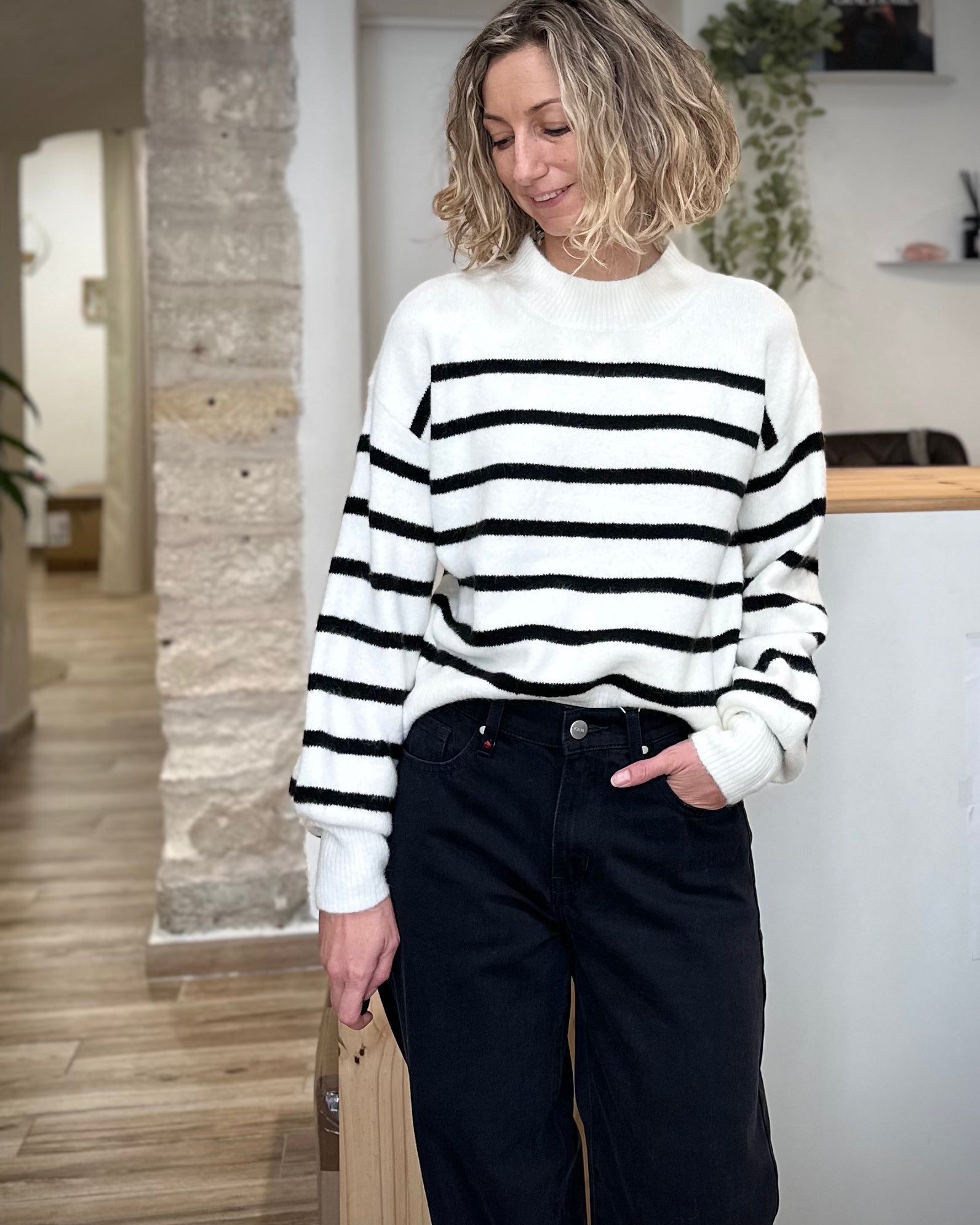 Femme portant un pull blanc rayé noir à col rond
