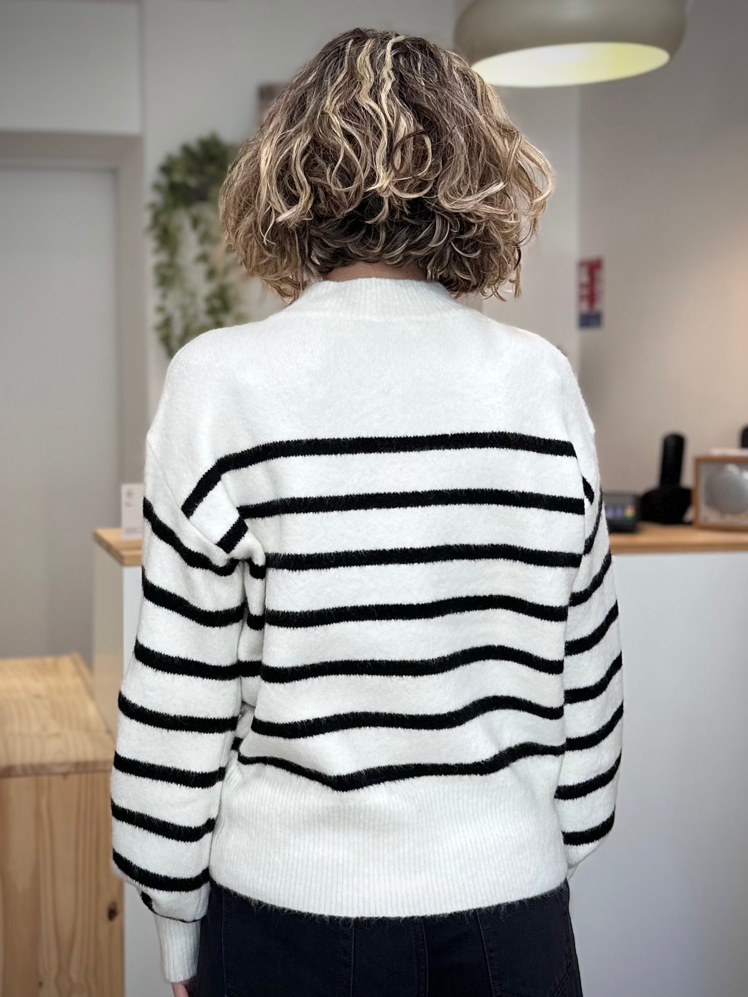 Femme de dos en pull rayé chic au look décontracté