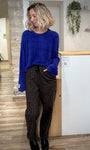 Look femme tendance avec pull bleu doudou et pantalon léopard