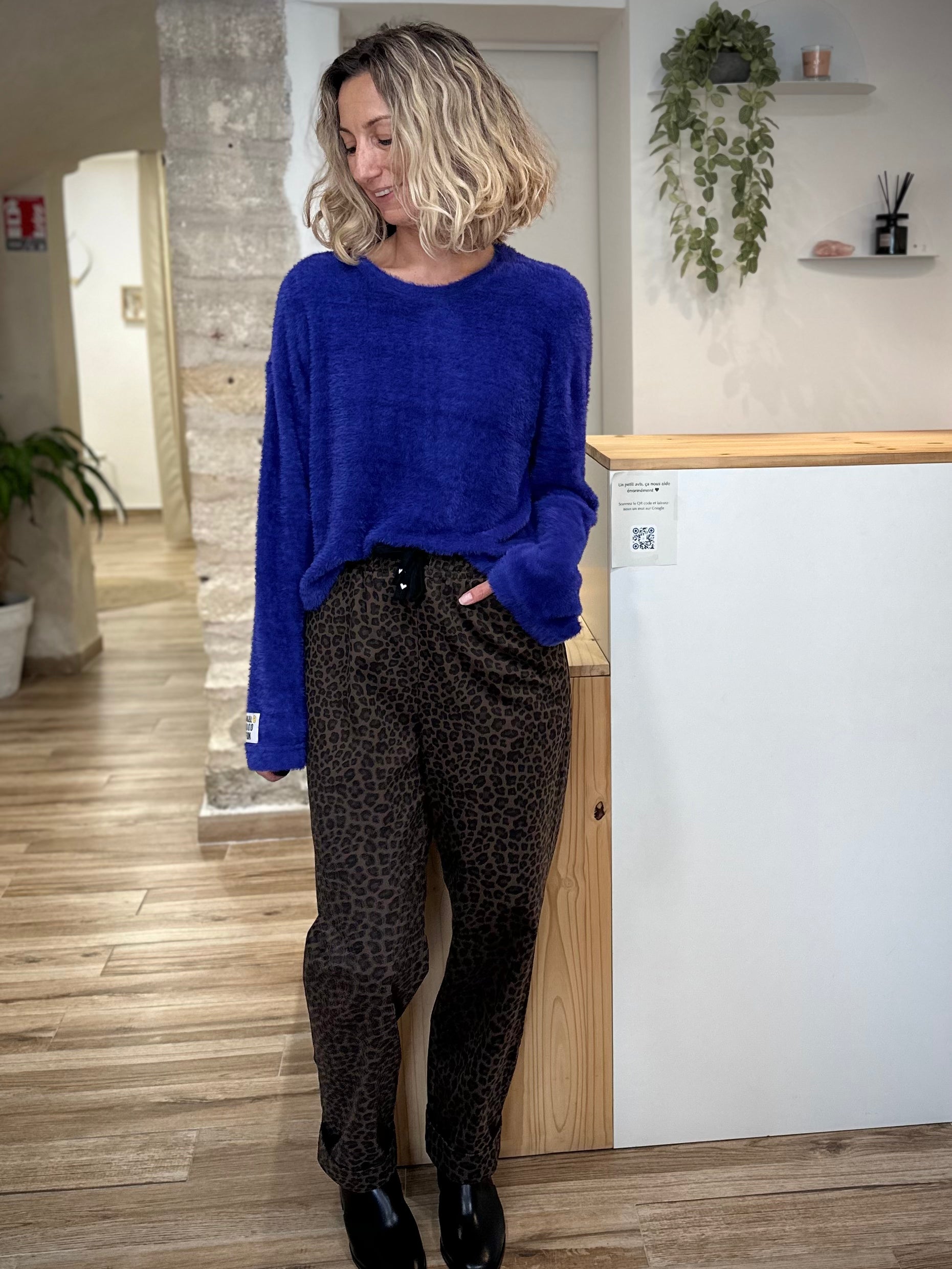 Look femme tendance avec pull bleu doudou et pantalon léopard