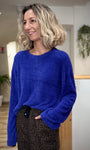 Femme portant un pull bleu confortable avec manches évasées