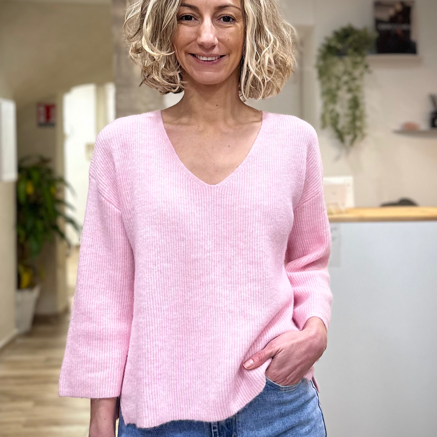 Femme portant un pull rose manches 3/4