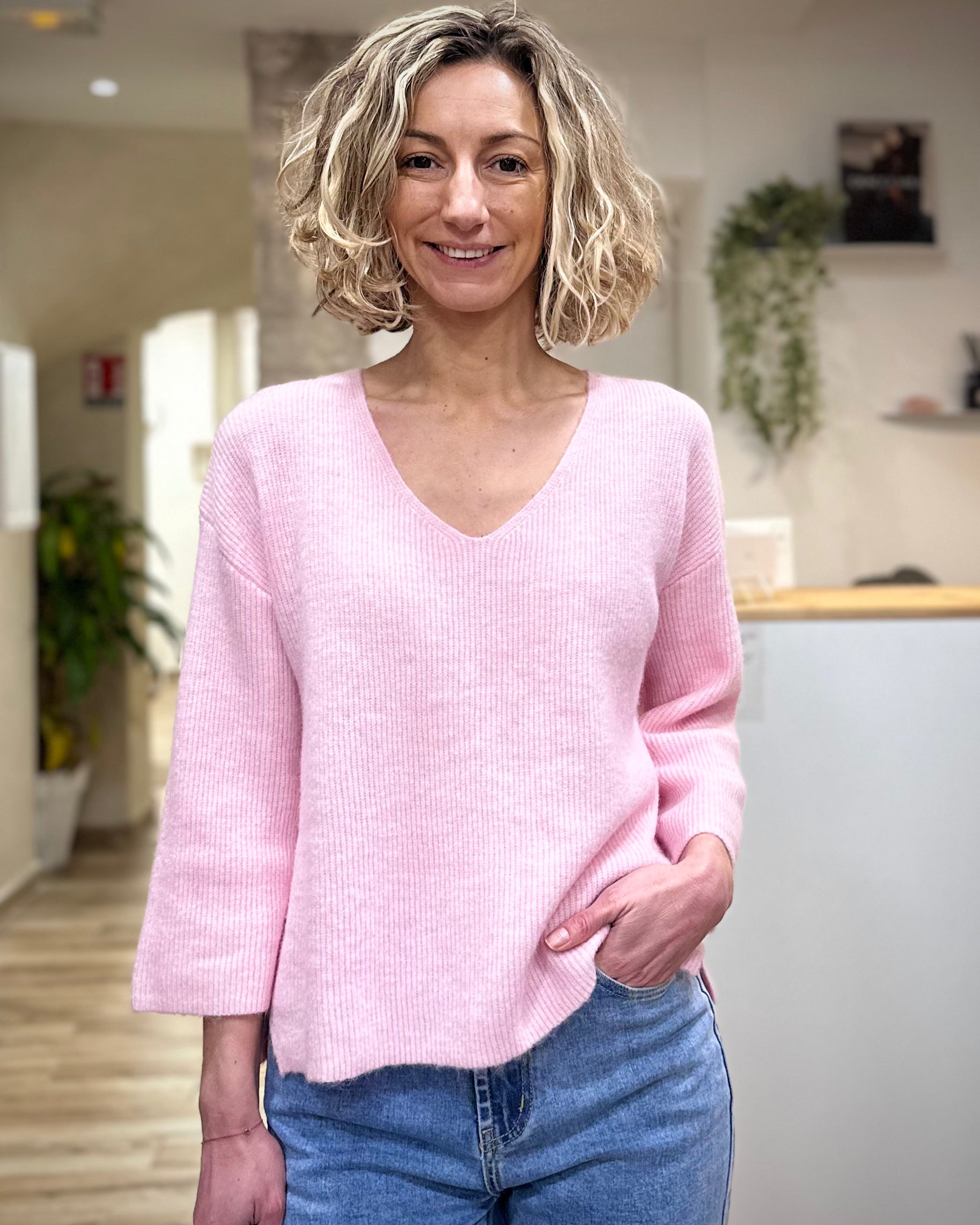 Femme portant un pull rose manches 3/4