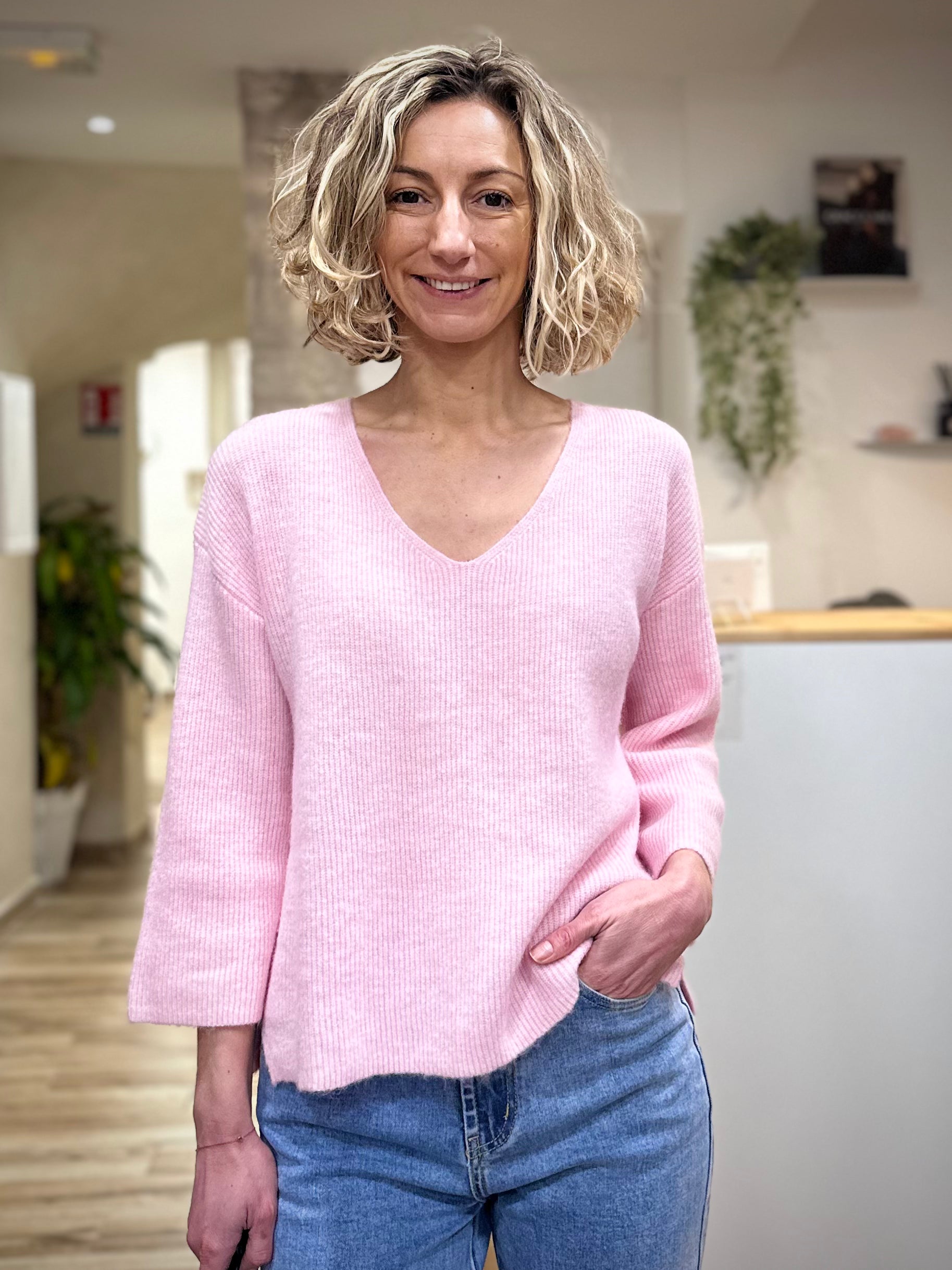 Femme portant un pull rose manches 3/4