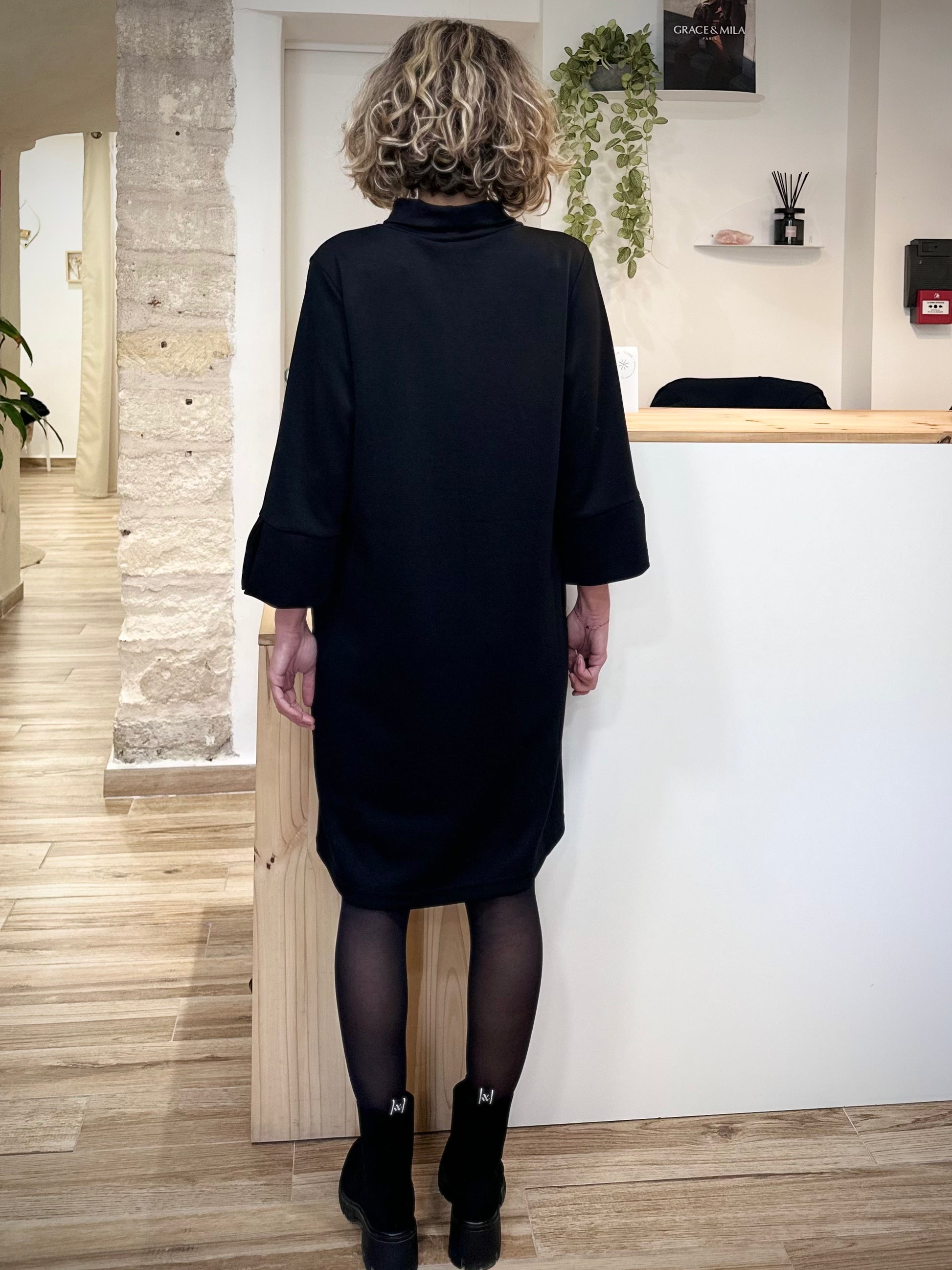 Femme de dos en robe noire élégante automne-hiver