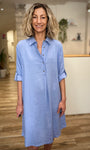 Femme souriante portant une robe estivale bleu ciel 