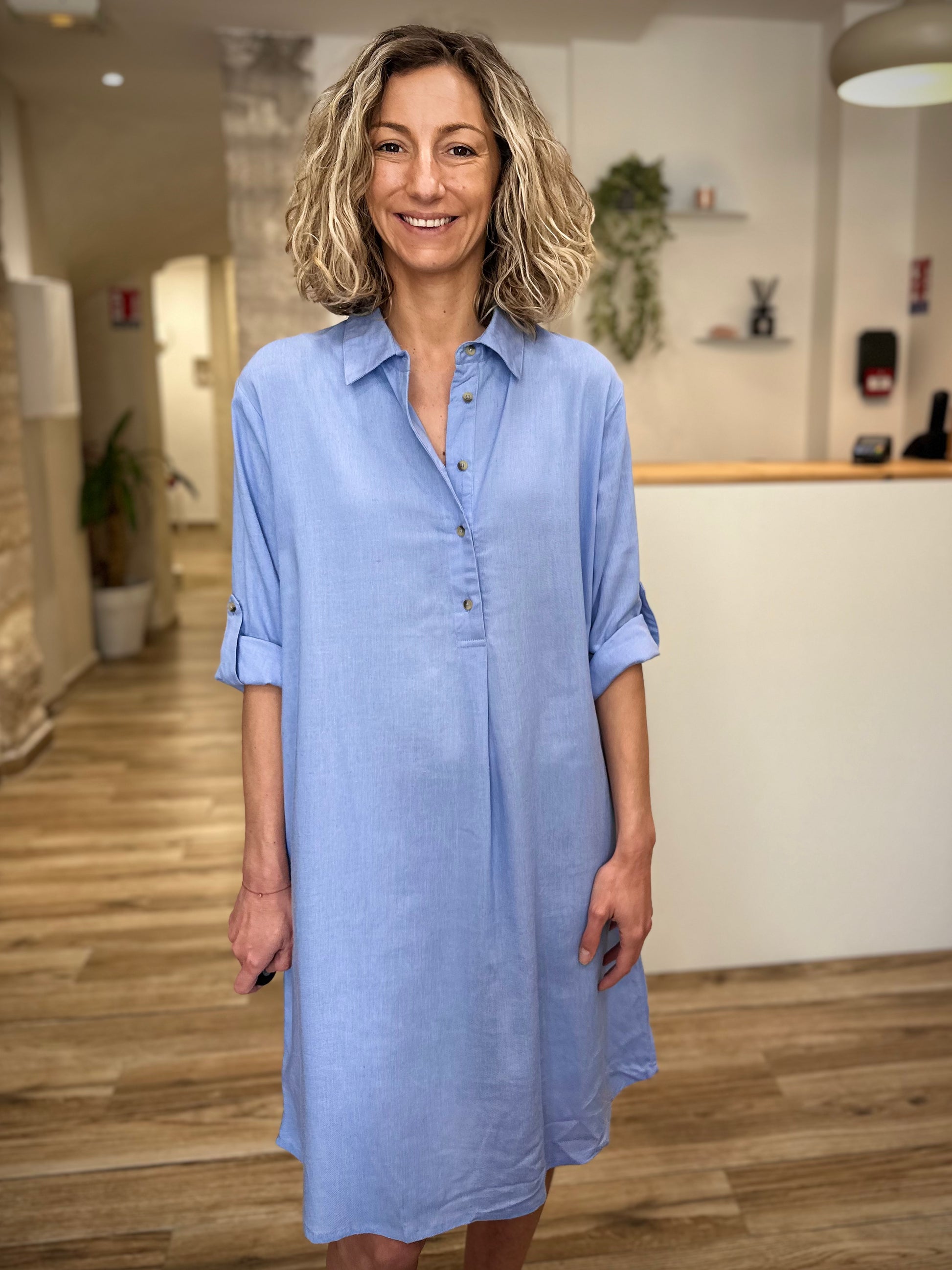 Femme souriante portant une robe estivale bleu ciel 